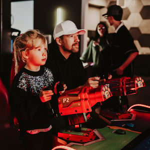 father and daughter playing arcade games together